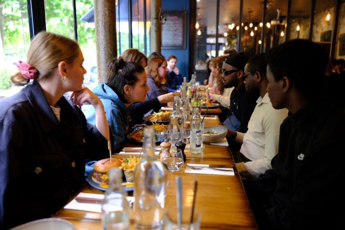 Des apprenants sont pris dans une intense discussion pendant qu'ils déjeunent ensemble au restaurant