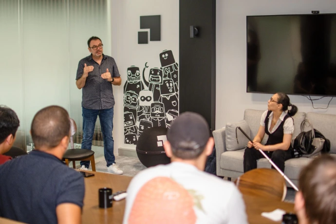 Gregory, expert accessibilité numérique du CFRP Valentin Haüy explique un concept sous le regard de Siham, témoin déficiente visuelle pendant une formation L'immersion A11Y